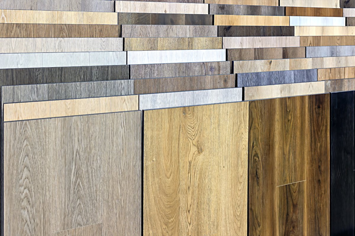 Display of various wooden floor panels in shades of light to dark brown arranged vertically, showcasing different textures and wood grains.